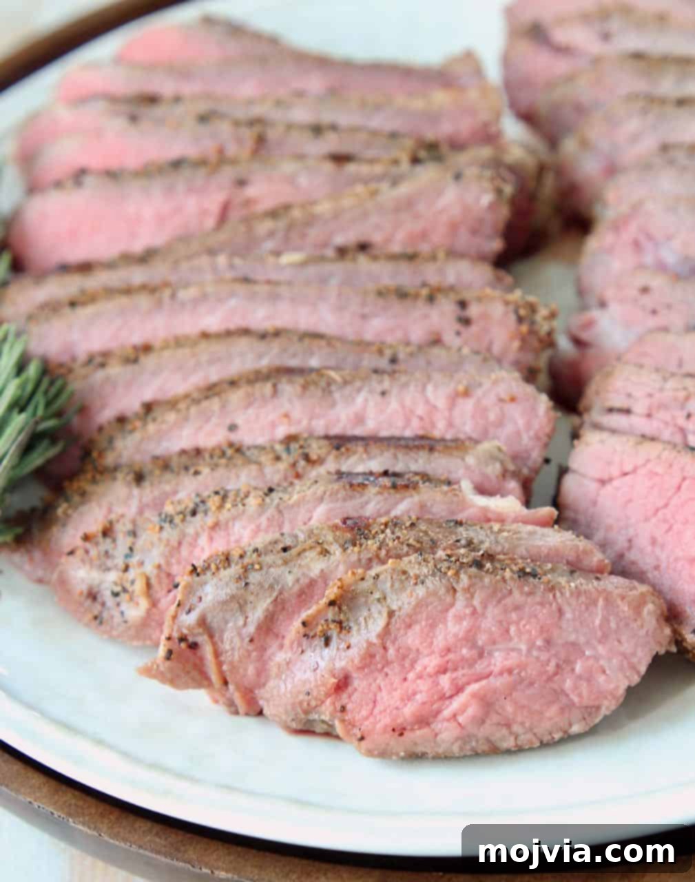 Perfectly Tender Sous Vide Tri Tip 3 Perfectly cooked and sliced sous vide tri tip steak on a white plate