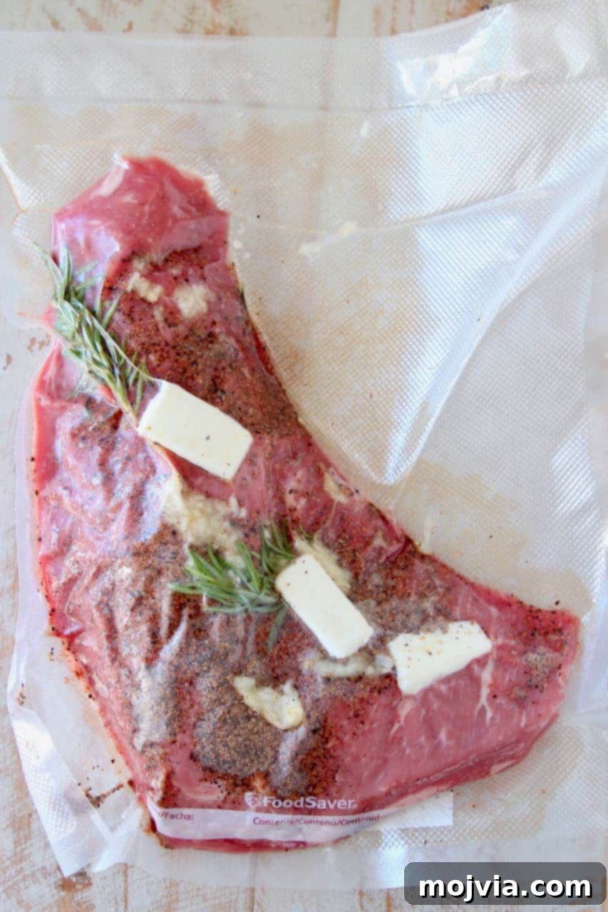 Perfectly Tender Sous Vide Tri Tip 4 Tri tip steak vacuum sealed in a bag with butter and fresh herbs for sous vide cooking
