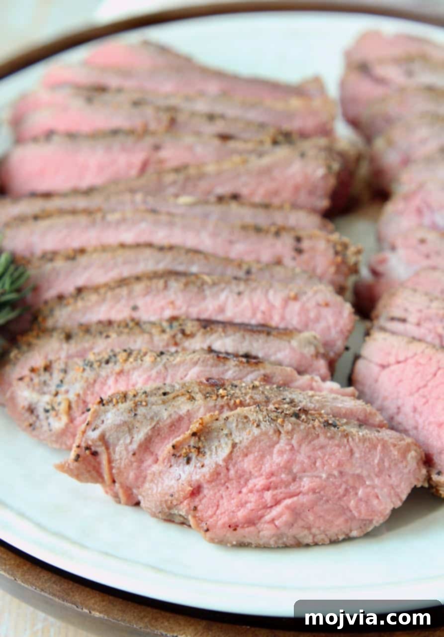 Perfectly Tender Sous Vide Tri Tip 5 Close-up of perfectly sliced tri tip steak on a white plate, ready to serve.