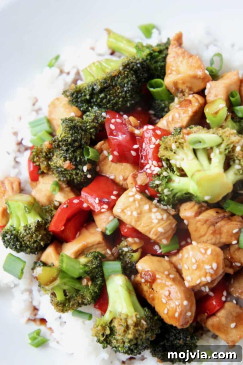 Sticky Teriyaki Chicken Stir Fry 2 Teriyaki chicken and broccoli stir fry served over rice on a white plate, ready to eat.