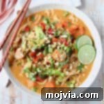 Overhead image of vegetable massaman curry in bowl with chopsticks and lime wedges on the side