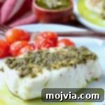 Pesto-Crusted Chilean Sea Bass 5 Sea bass covered in pesto on plate with cherry tomatoes