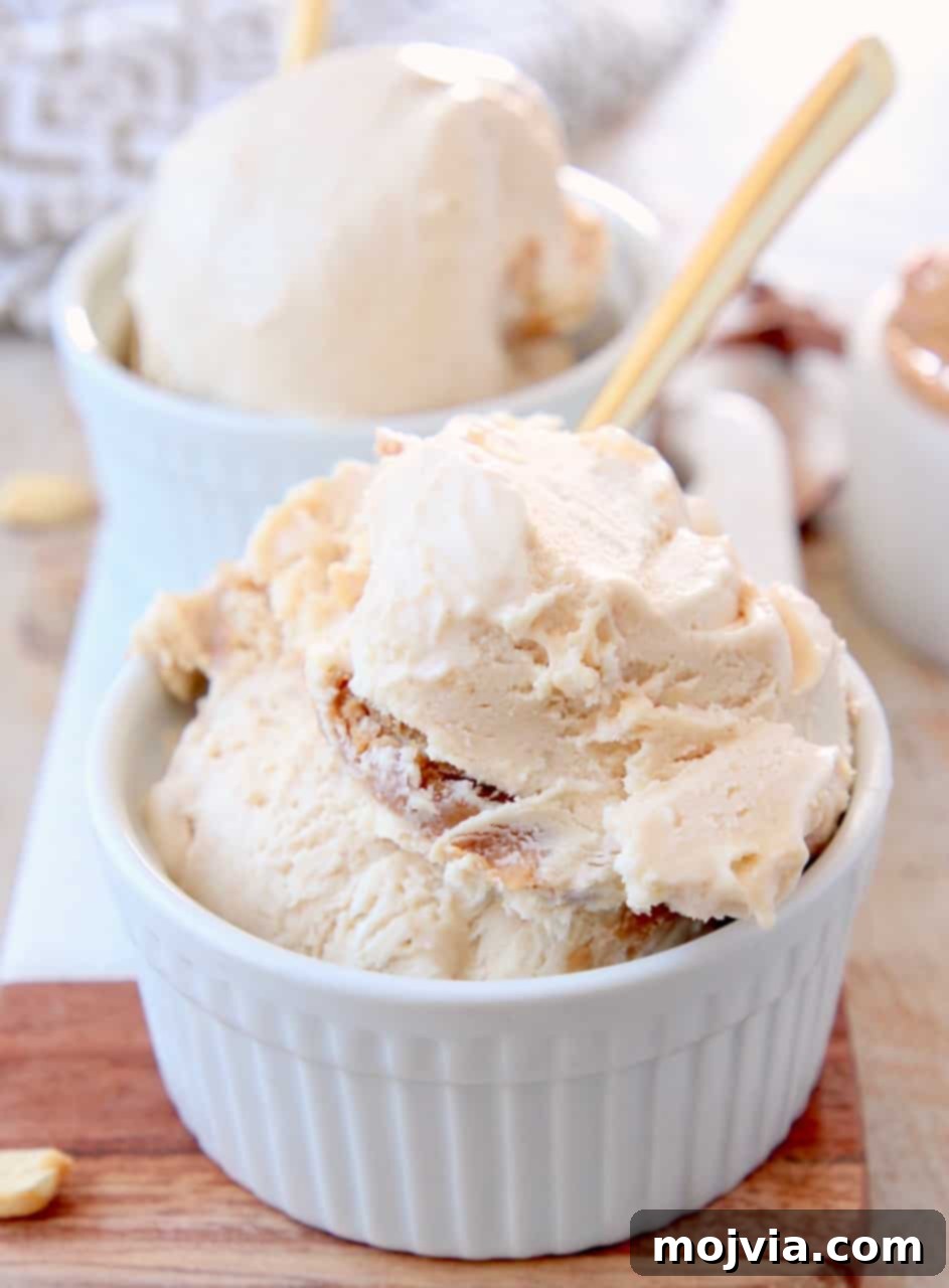 Creamy No-Churn Peanut Butter Ice Cream 5 Close-up of scoops of no-churn peanut butter ice cream in white bowls, garnished with golden spoons, ready to be enjoyed.