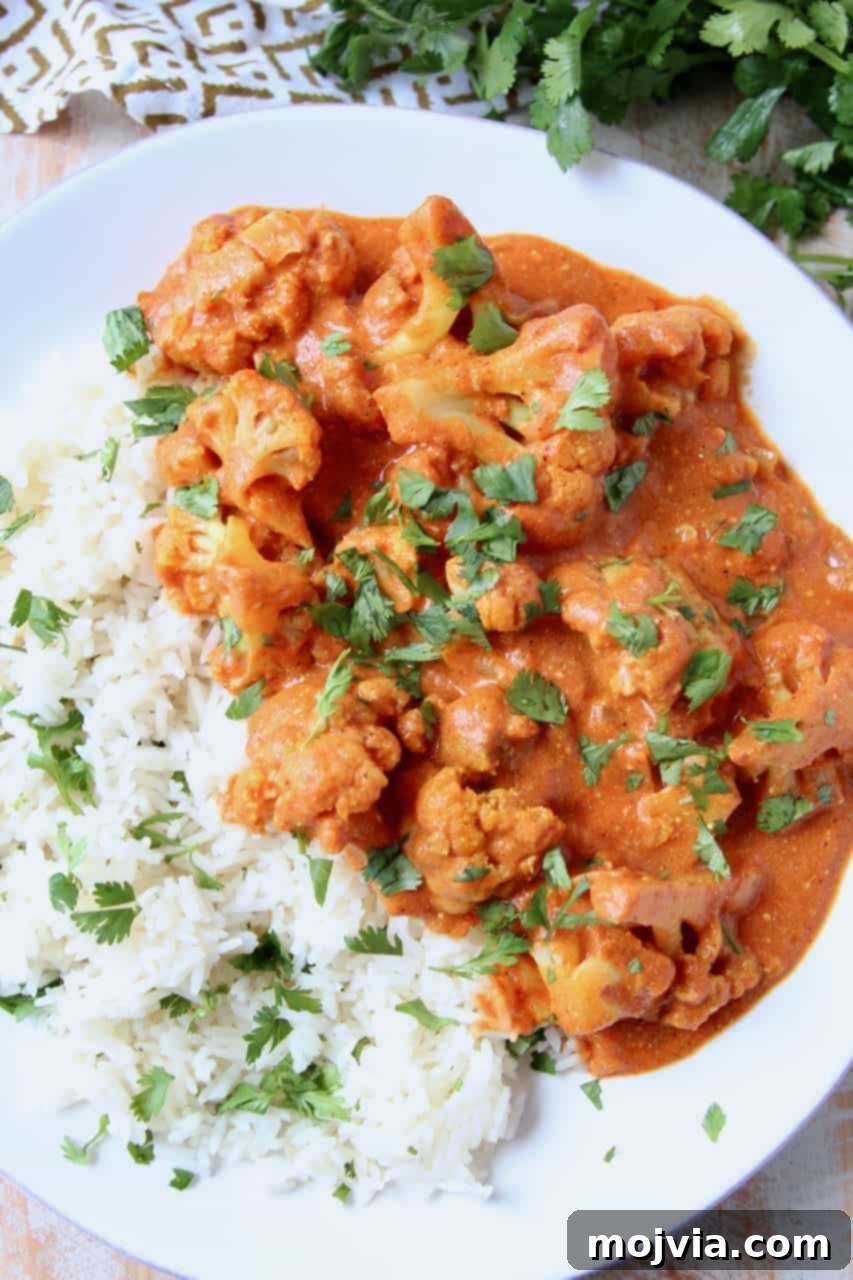 Creamy Indian Butter Cauliflower Curry 2 Vibrant Cauliflower Curry served with fluffy basmati rice and fresh cilantro garnish