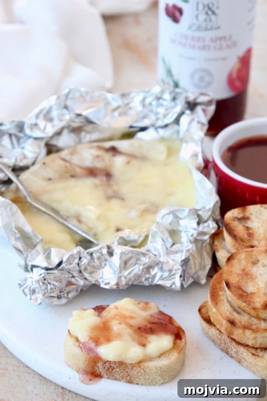 Grilled Bites Charcuterie Board 6 Melted grilled brie with cherry apple rosemary glaze in foil, served alongside toasted baguette slices