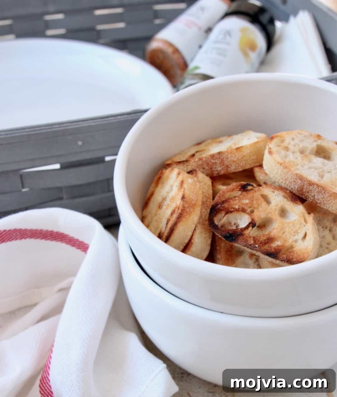 Grilled Bites Charcuterie Board 8 Close-up of golden brown grilled baguette slices in a decorative bowl
