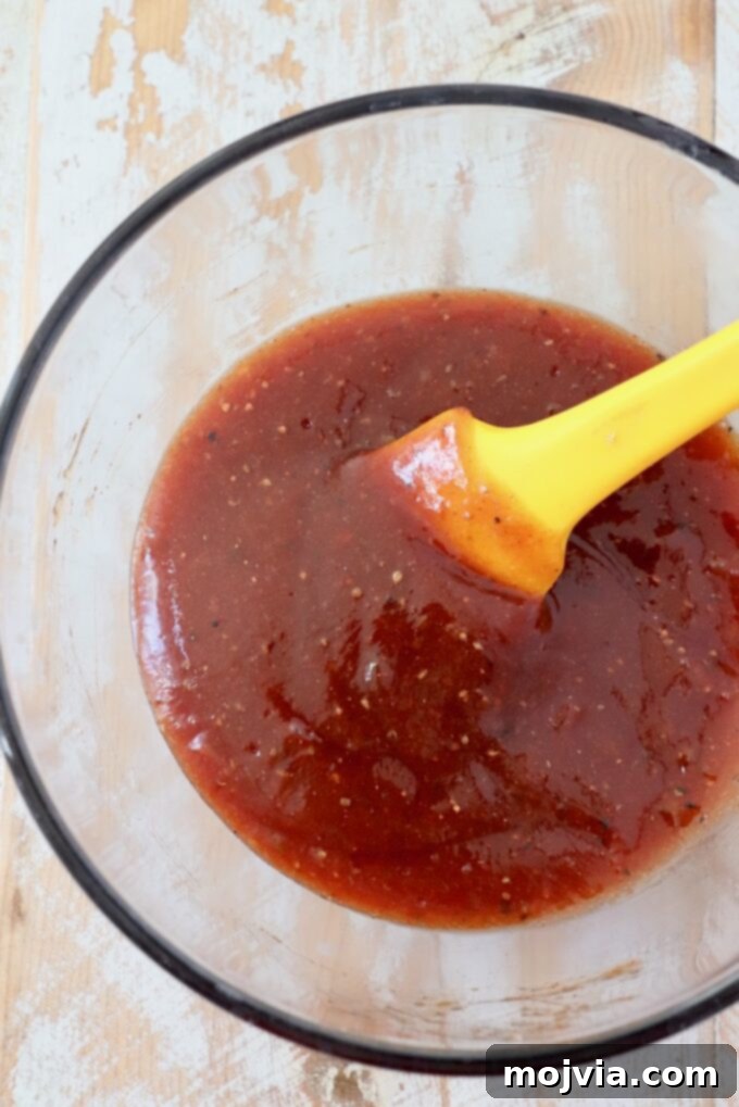 Homemade BBQ sauce smoothly mixed in a small glass bowl with a spatula, ready for use.