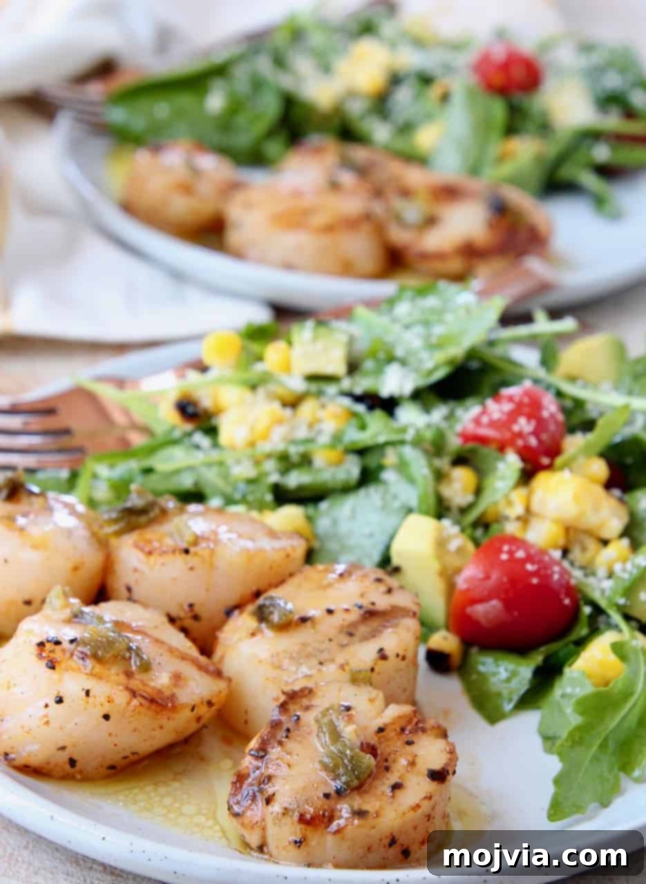 Grilled Scallops with Zesty Jalapeño-Lemon Butter 2 Platter of perfectly grilled scallops, golden brown and served alongside a fresh arugula corn salad. A vibrant and appealing seafood dish ready to be enjoyed.