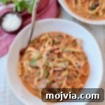 Overhead image of pasta in mushroom sauce in bowl with fork