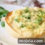 Golden Spaghetti Squash Mac and Cheese Bake 5 Half of a roasted spaghetti squash on plate topped with fresh chopped basil