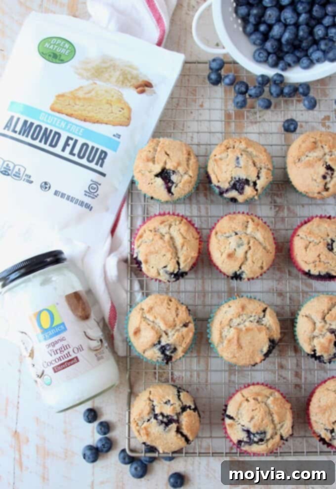Guilt-Free Almond Blueberry Muffins 5 An overhead shot of freshly baked low-carb almond flour blueberry muffins cooling on a wire rack, showcasing their golden tops and tender texture.