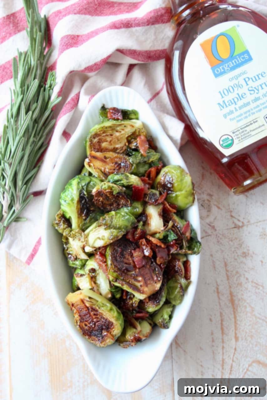 Roasted Maple Bacon Brussels Sprouts 4 overhead image of brussels sprouts in serving dish with maple syrup jar on the side