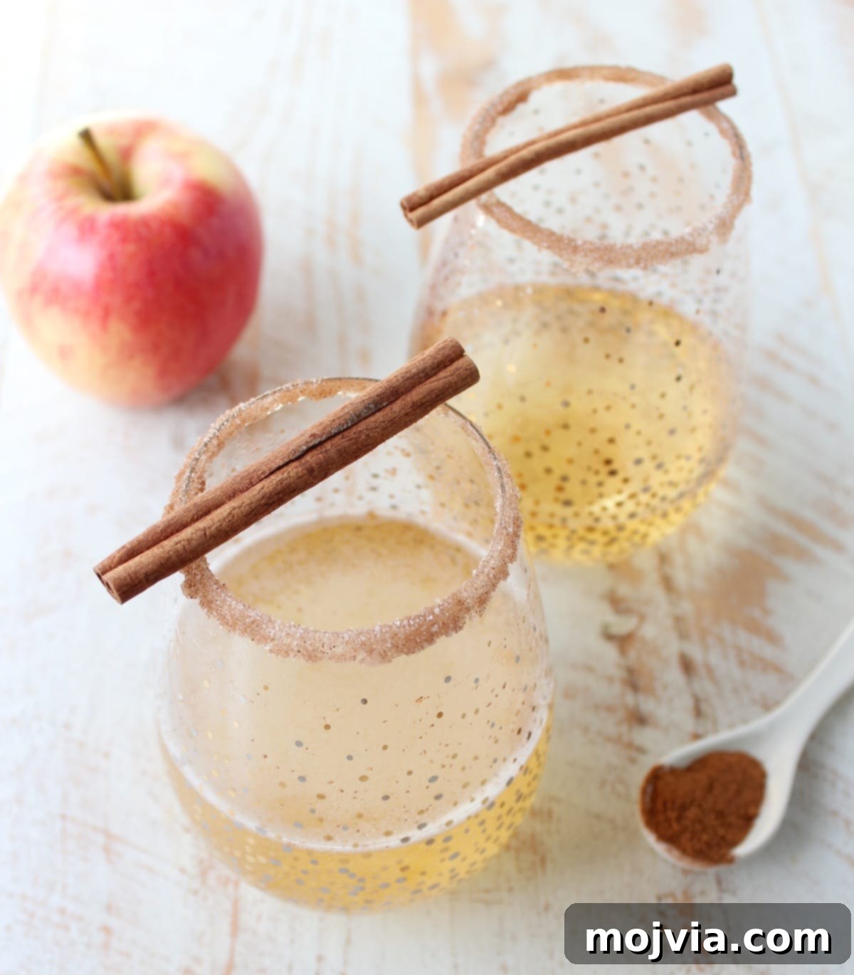Crisp Apple Champagne Fizz 4 Finished apple cider champagne cocktail with a beautiful cinnamon sugar rim, sparkling and ready to be enjoyed, showcasing the festive detail.