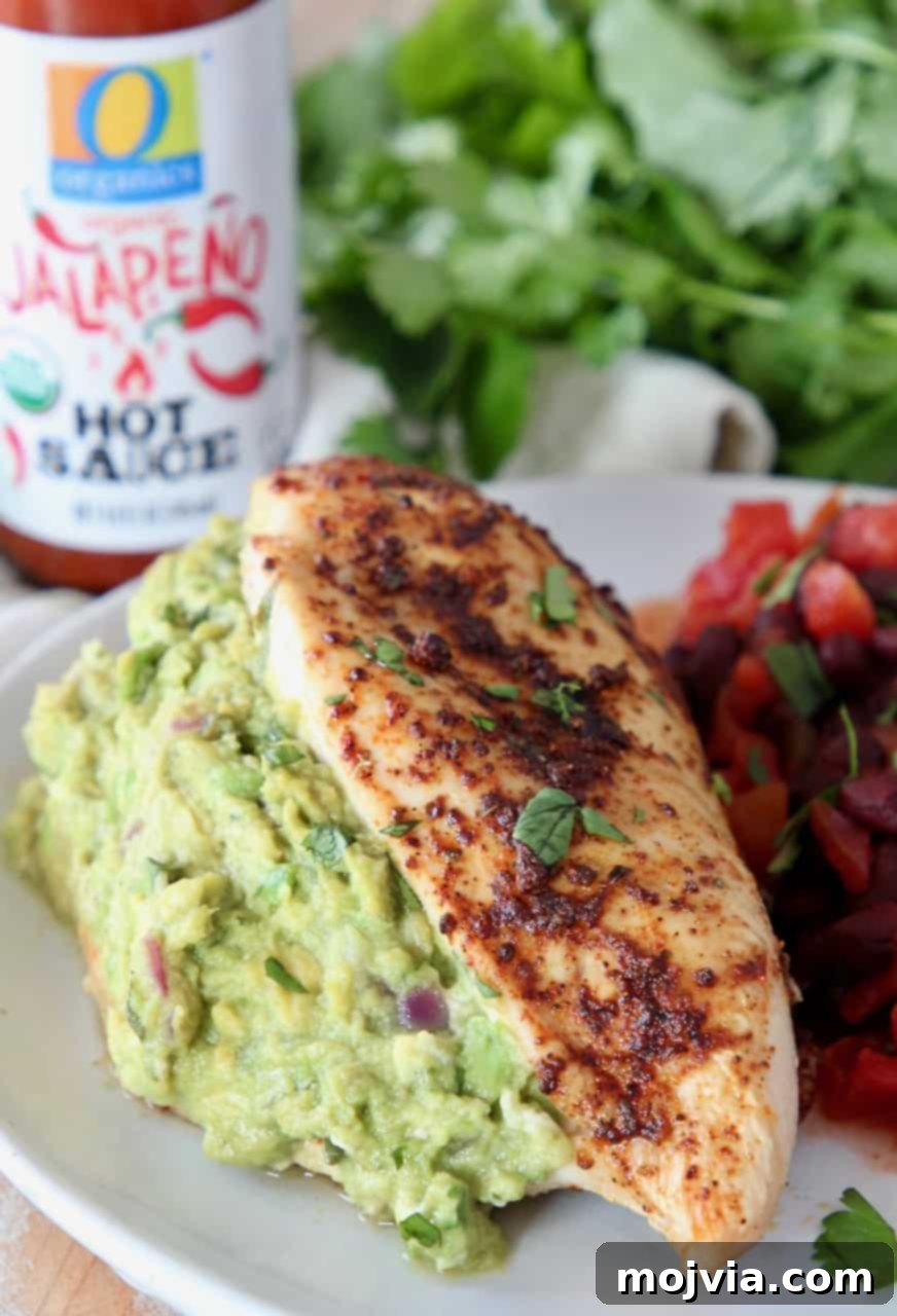 guacamole stuffed chicken breast on plate with black beans, ready to be served
