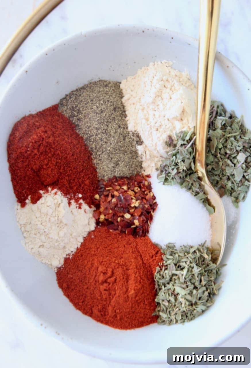 Bayou Blast Seasoning 2 Aromatic blend of homemade Cajun spices in a bowl with a gold spoon, ready for cooking