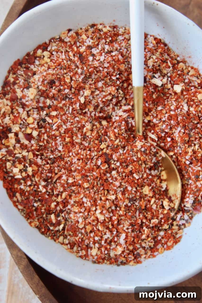 Montreal Steak Spice 2 A bowl filled with freshly made homemade Montreal Steak Seasoning, ready for use, with a spoon resting in it.