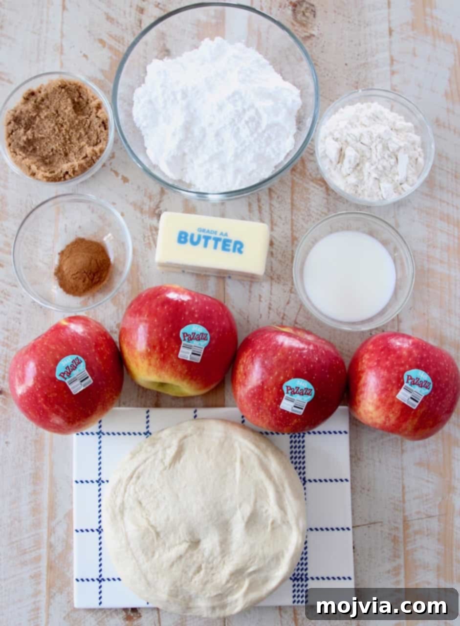 Cinnamon Streusel Apple Dessert Pizza 3 Overhead image of all the ingredients for apple dessert pizza laid out on a white surface, showcasing fresh Pazazz apples, flour, sugar, and butter.