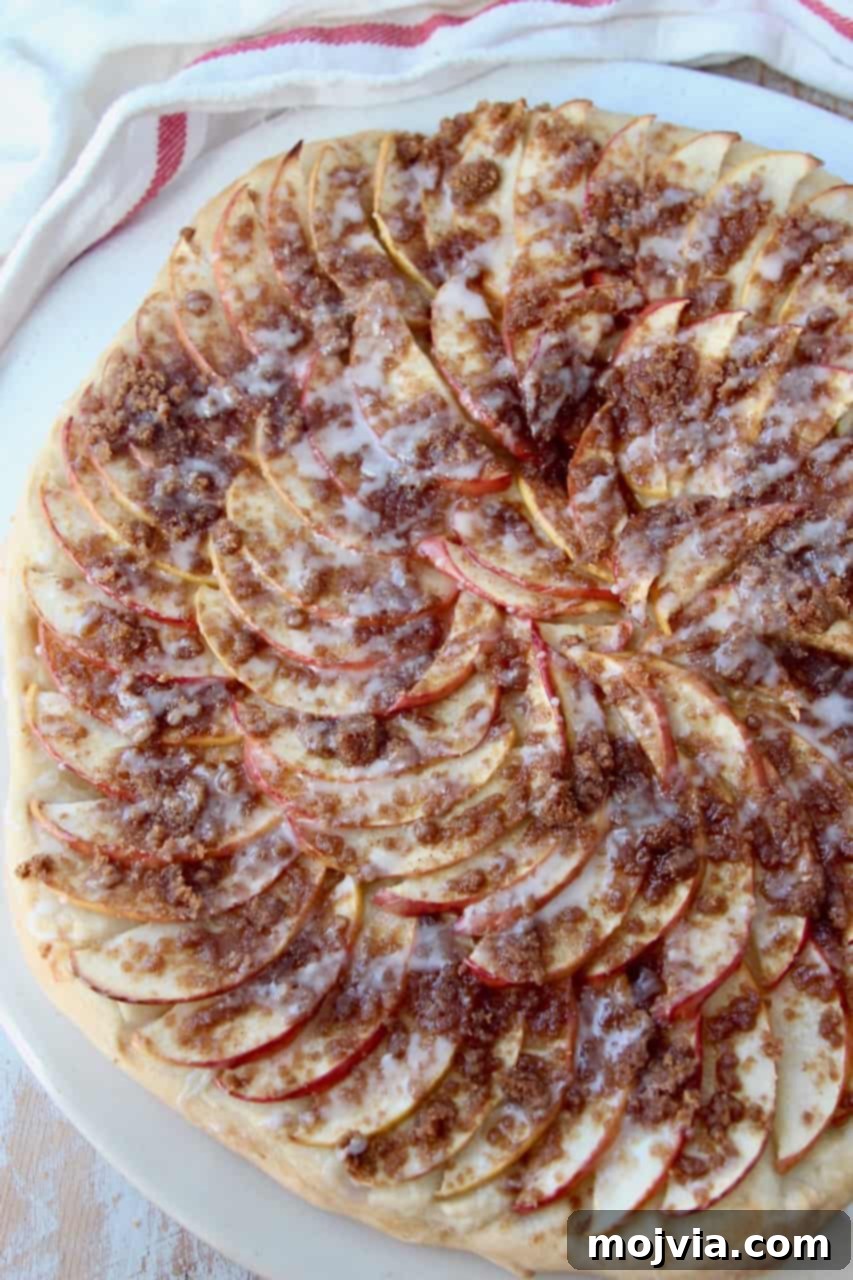 Cinnamon Streusel Apple Dessert Pizza 5 Overhead image of a fully baked apple dessert pizza, drizzled with icing and ready to be served.