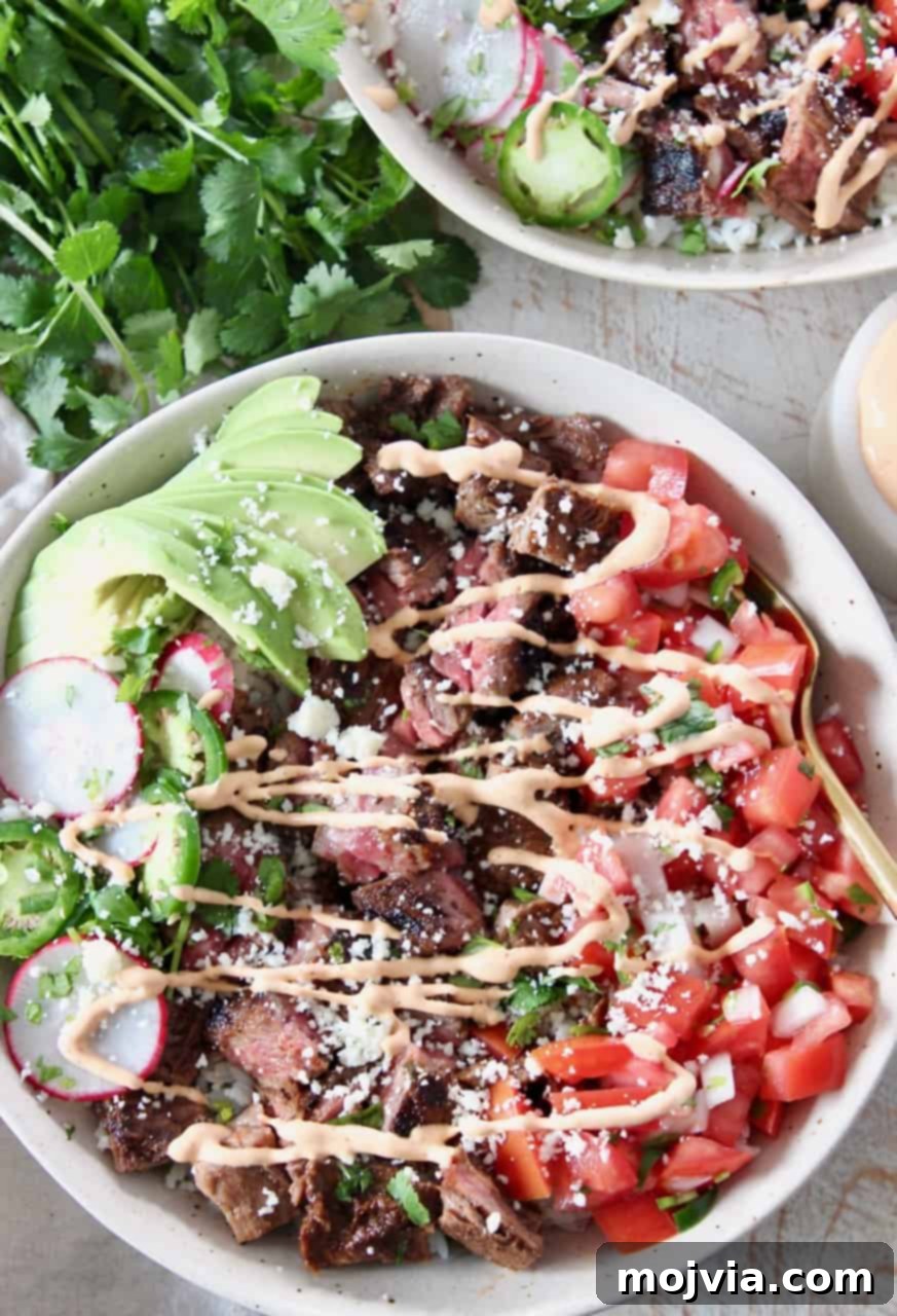 Loaded Carne Asada Bowl 6 Carne asada bowl with chipotle crema drizzle on top, showcasing fresh ingredients