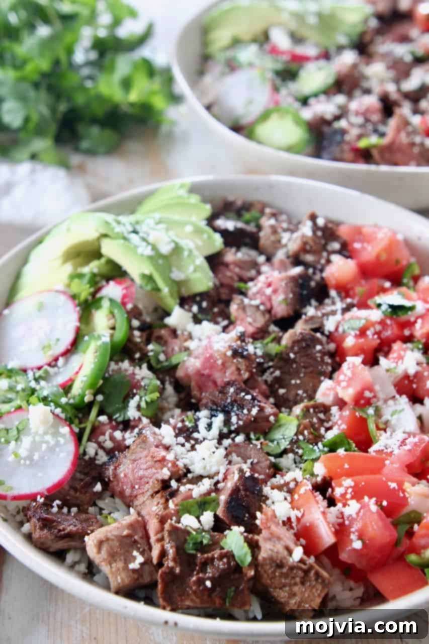 Loaded Carne Asada Bowl 7 Grilled steak in a bowl with assorted fresh vegetables and rice, ready to eat