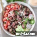 Diced carne asada in a bowl with avocado and pico de gallo