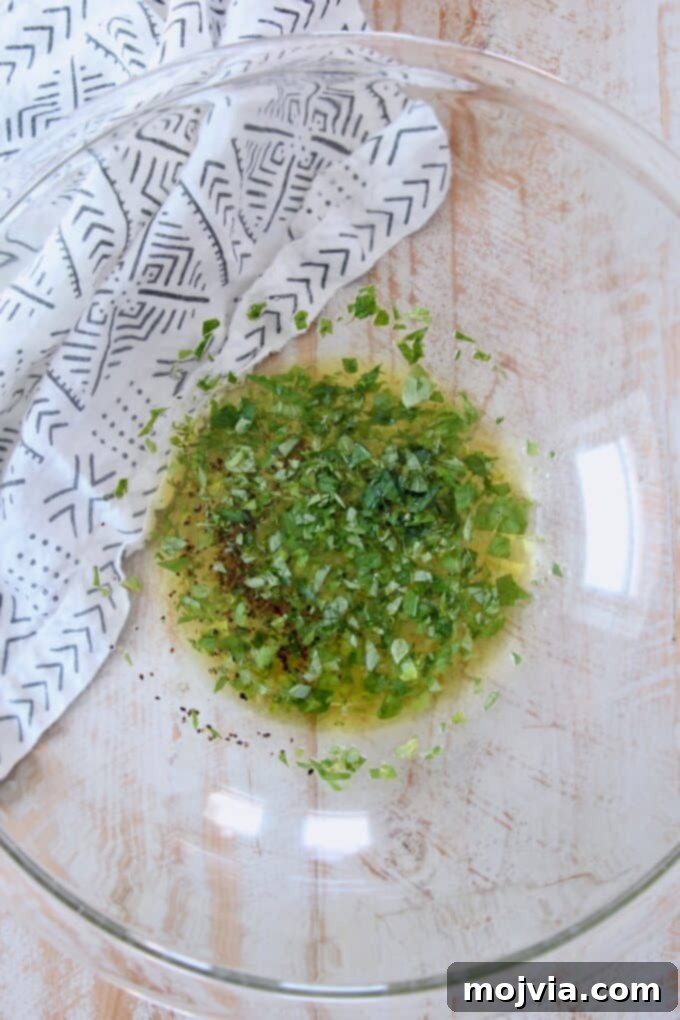 Bright Mediterranean Orzo Salad 4 Close-up of a homemade lemon herb dressing in a glass bowl.