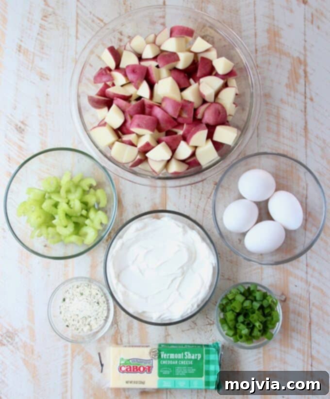 Quick and Creamy Instant Pot Cheddar Ranch Potato Salad 3 Assortment of fresh ingredients laid out for making cheddar ranch potato salad, including potatoes, eggs, sour cream, cheese, and herbs.
