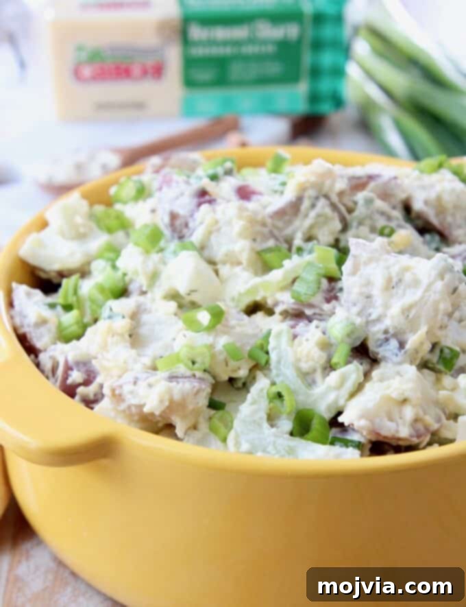 Quick and Creamy Instant Pot Cheddar Ranch Potato Salad 6 Close-up of freshly made potato salad with visible celery and green onions in a yellow serving bowl.