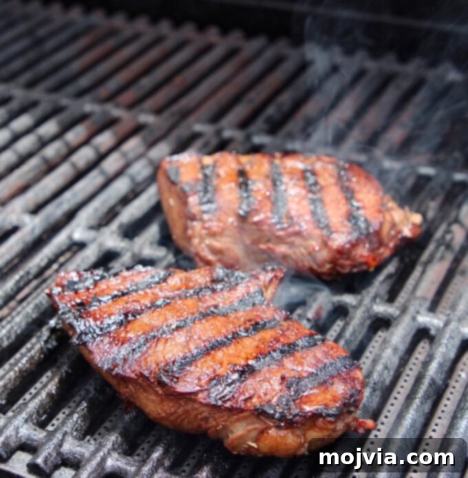 Two sizzling sirloin steaks perfectly placed on a hot grill, ready for searing