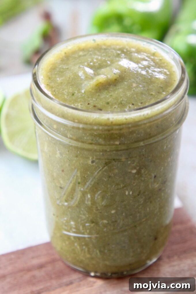 Vibrant Verde Enchilada Sauce 6 A beautifully presented mason jar filled with bright green enchilada sauce, ready to be used in various Mexican dishes, highlighting its appealing color and texture.