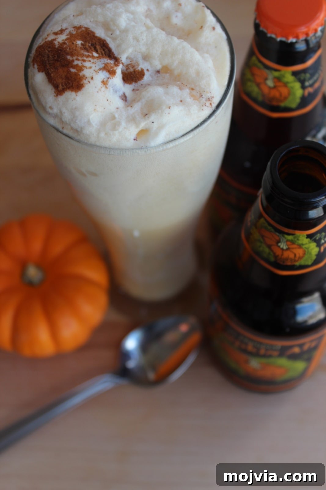 Close-up of a finished Pumpkin Ale Float with foam and cinnamon in a tall glass.