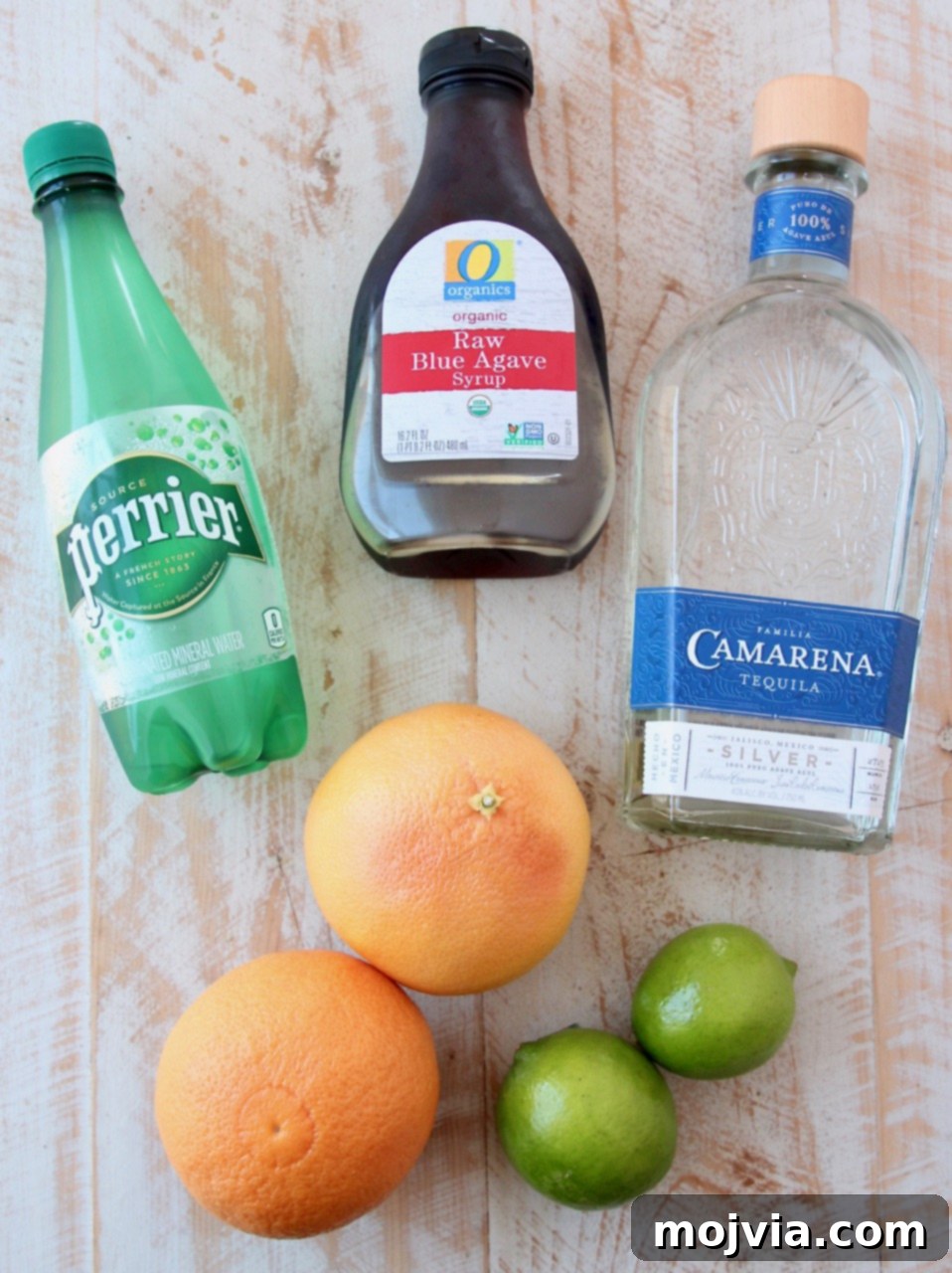 Whispers of Paloma 3 Ingredients for a Paloma cocktail laid out: tequila, grapefruit, lime, agave nectar, sparkling water, and Tajin