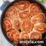 cooked pizza rolls in black baking dish