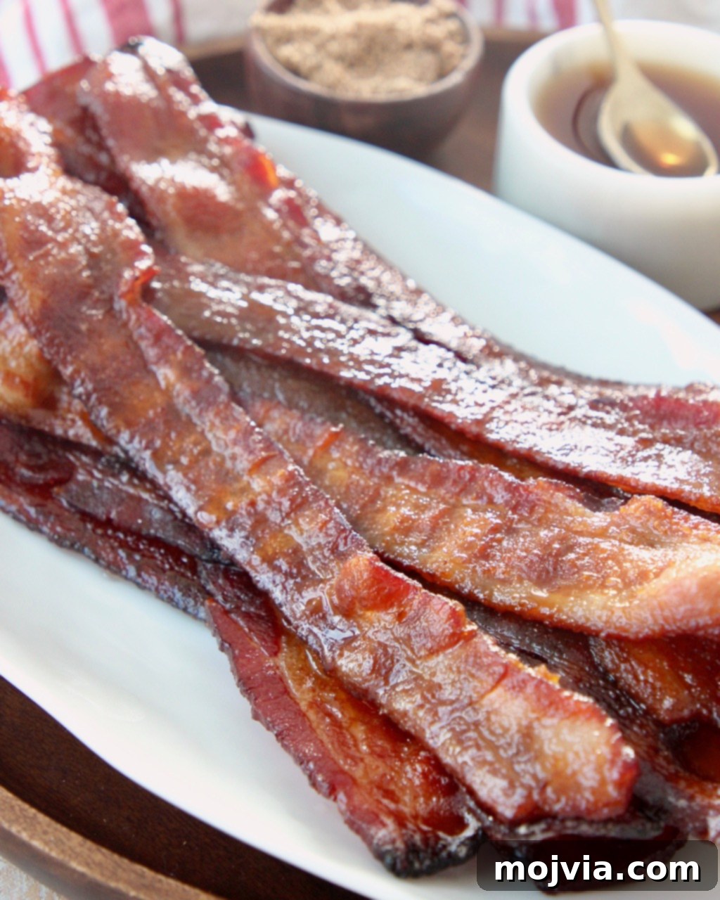 Pig Candy 5 A generous pile of freshly cooked candied bacon strips, glossy with caramelized sugar, ready to be enjoyed as a sweet and savory treat.