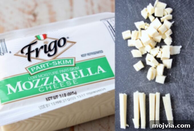 Kurt's Signature Pan Pizza 5 a block of low-moisture mozzarella cheese next to cubes of sliced mozzarella on a cutting board