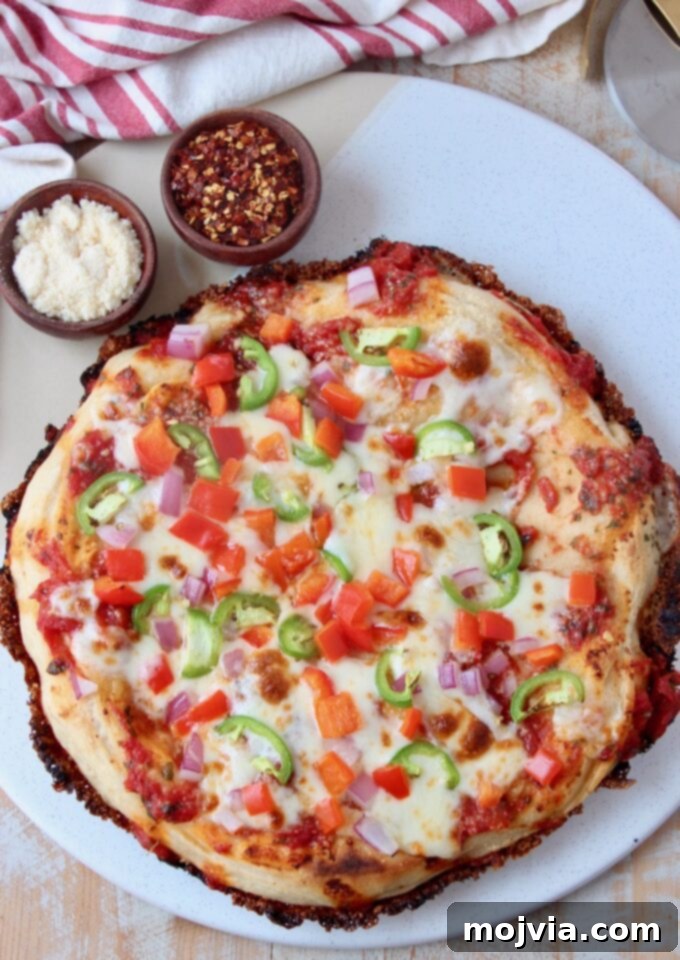 Kurt's Signature Pan Pizza 10 a beautifully cooked pan pizza topped with a variety of fresh vegetables on a marble serving tray