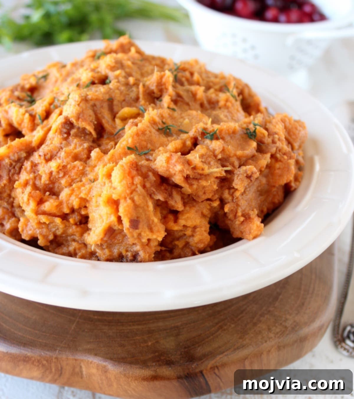a close-up of smooth, creamy mashed sweet potatoes in a rustic white bowl, ready to serve