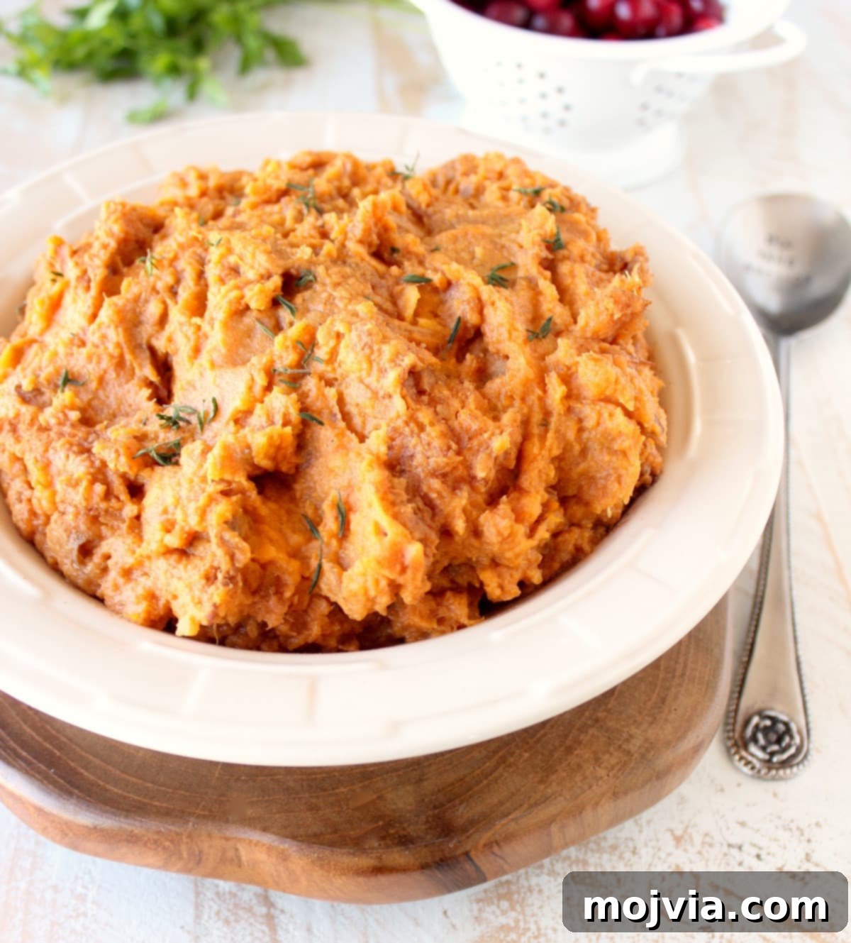 a vibrant bowl of mashed sweet potatoes, ready to be served at a dinner setting