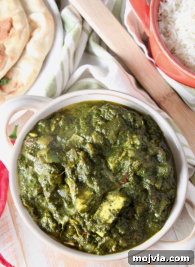 Spinach Paneer Curry 6 A beautiful presentation of Palak Paneer in a white serving bowl, garnished.