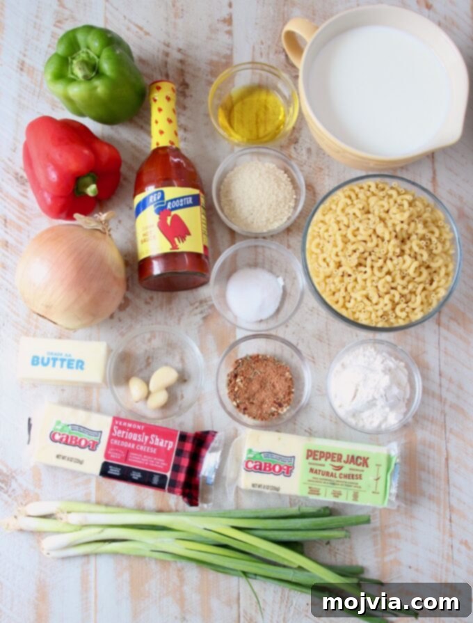 Bayou Blend Mac and Cheese 3 A vibrant display of fresh ingredients laid out for making Cajun Mac and Cheese, including bell peppers, onion, garlic, cheeses, and spices.