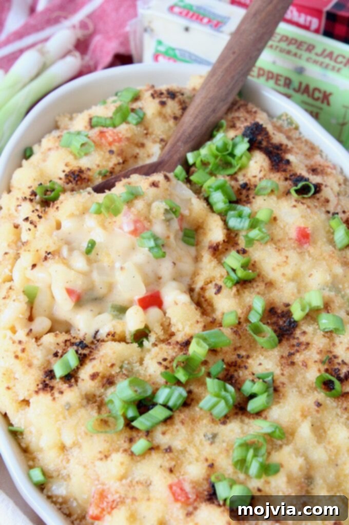 Bayou Blend Mac and Cheese 7 A bowl of creamy Cajun Mac and Cheese generously topped with freshly diced green onions, ready to be enjoyed.