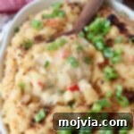 Bayou Blend Mac and Cheese 9 Cajun Macaroni and Cheese in a baking dish with a serving spoon, highlighting the crispy topping.