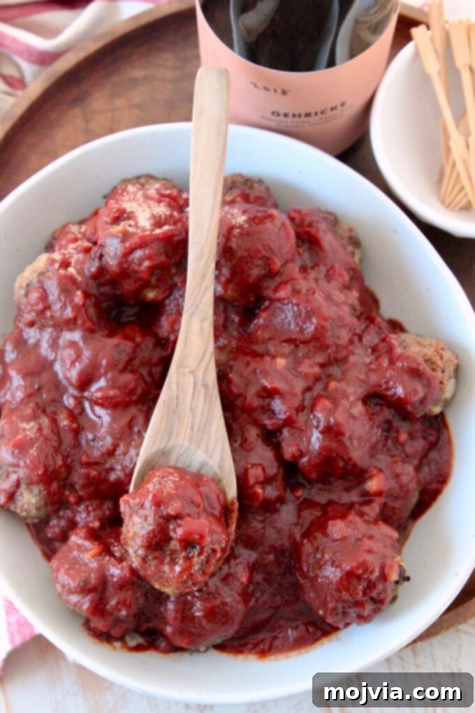 Red Wine Infused BBQ Beef Meatballs 7 bbq sauce covered meatballs in bowl with wooden spoon