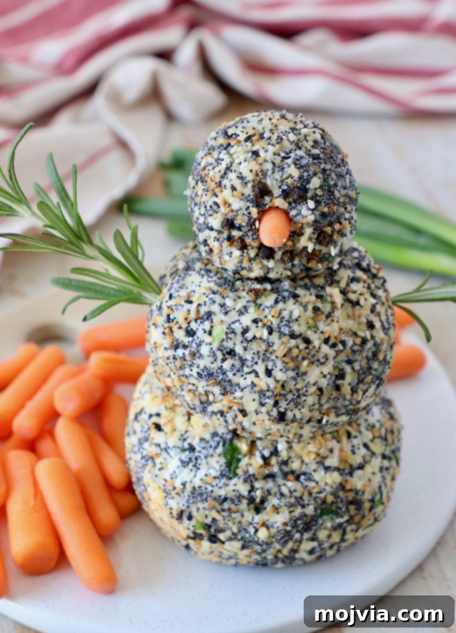 Everything Bagel Cheddar Party Ball 6 cheese ball snowman on serving tray with carrot sticks