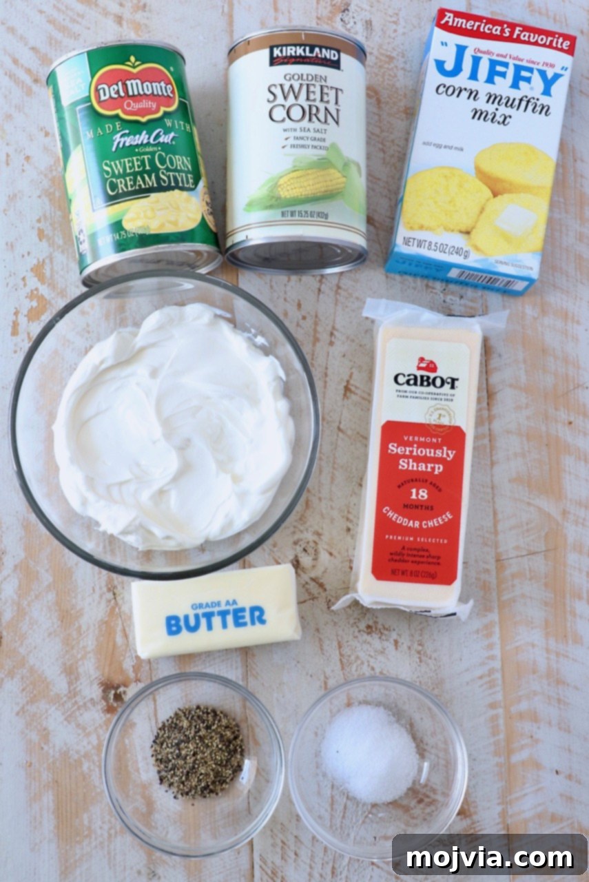 Golden Corn & Cheddar Delight 3 a collection of corn casserole ingredients, including Jiffy mix, canned corn, sour cream, butter, and cheddar cheese