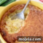 Golden Corn & Cheddar Delight 8 corn casserole in yellow baking dish with silver serving spoon