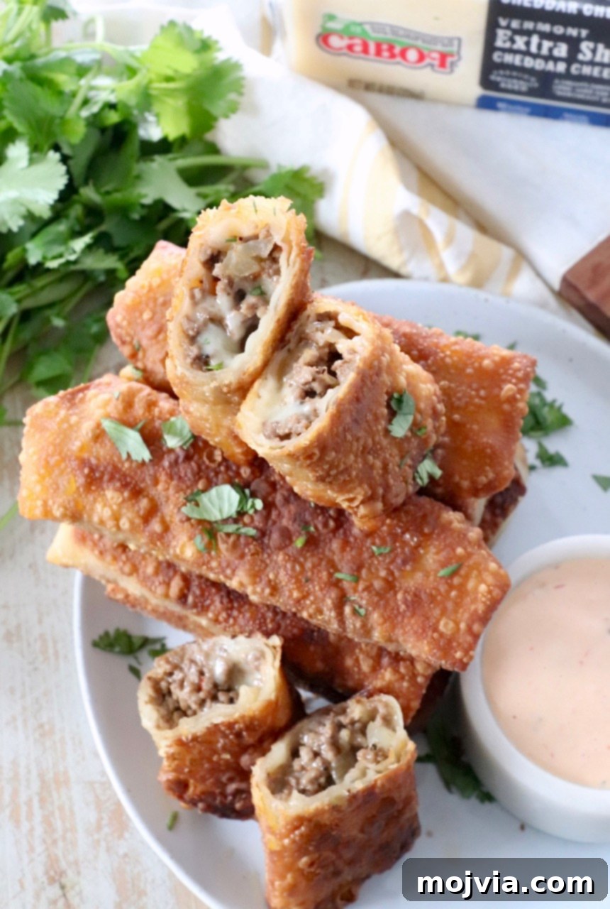 Crispy Cheeseburger Egg Rolls Air Fryer Pan Fry 7 cheeseburger egg rolls cut in half on plate