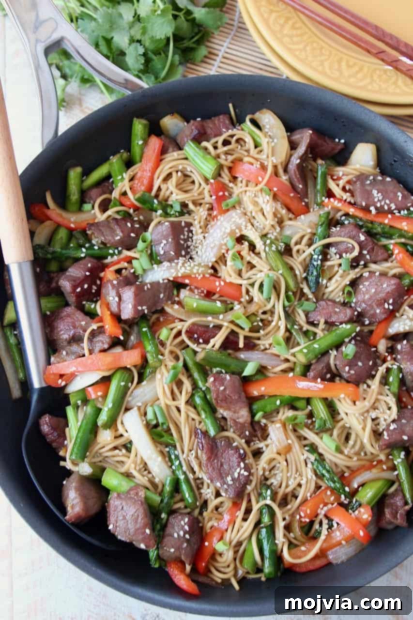 Perfect Stir-Fry Sauce 5 An appetizing overhead view of a robust beef stir fry featuring tender beef strips, perfectly cooked noodles, and a colorful array of vibrant vegetables, all prepared in a large skillet and ready to be served.