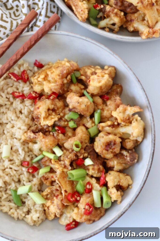 Spicy Tso Style Cauliflower Bites 2 fried cauliflower tossed in general tso sauce in bowl with brown rice