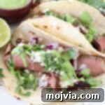 steak tacos on plate with lime and cilantro